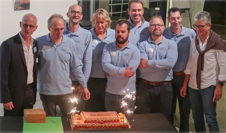 L'équipe et ses associés autour du gâteau d'anniversaire